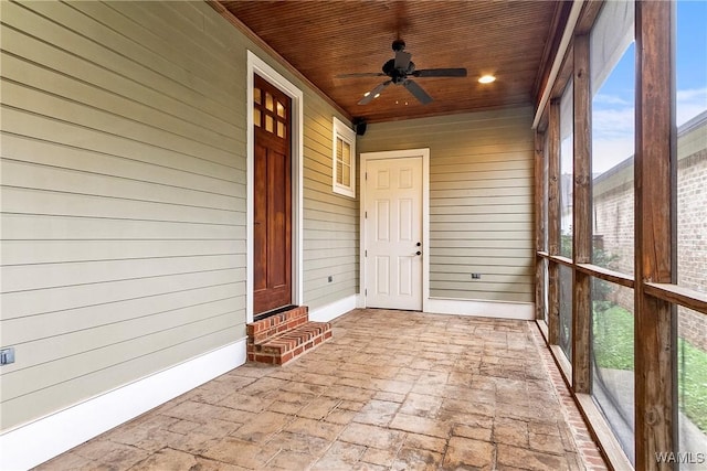 unfurnished sunroom with ceiling fan and wooden ceiling