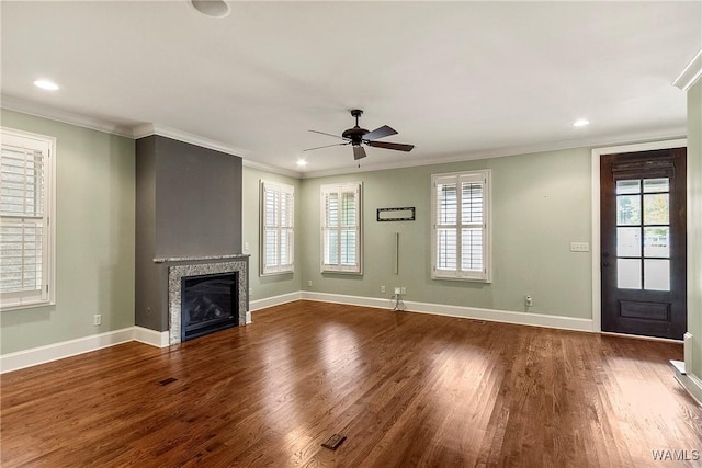 unfurnished living room featuring hardwood / wood-style flooring, ceiling fan, and crown molding