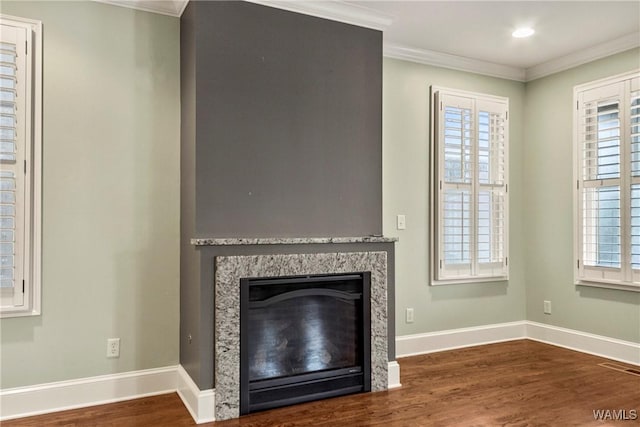 unfurnished living room featuring wood-type flooring and ornamental molding