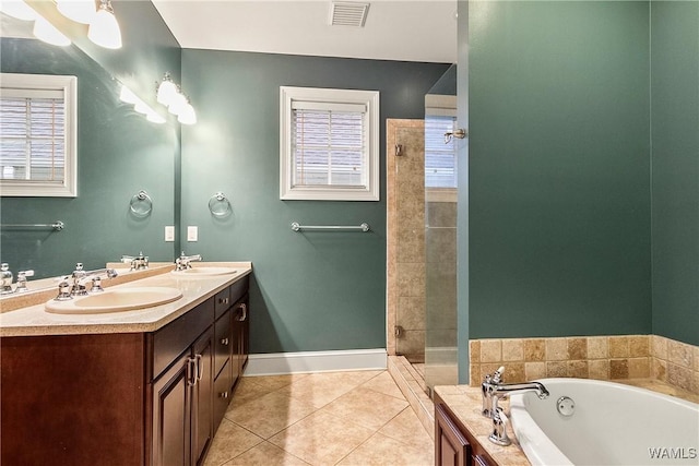 bathroom featuring tile patterned flooring, vanity, and shower with separate bathtub