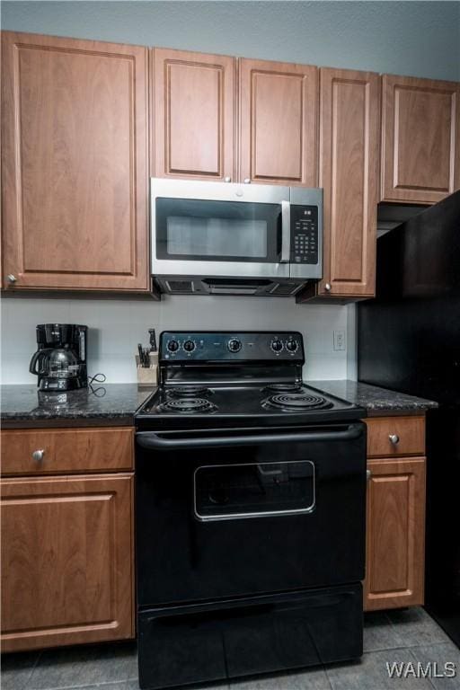 600 13th St E Unit 532, Tuscaloosa, AL 35401 - kitchen featuring black appliances, dark stone counters, brown cabinets, and dark tile patterned floors