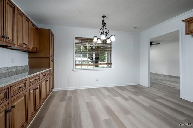 4205 Cloverdale Est, Northport, AL 35473 - unfurnished dining area featuring light wood-style flooring, ornamental molding, baseboards, a chandelier, and a ceiling fan