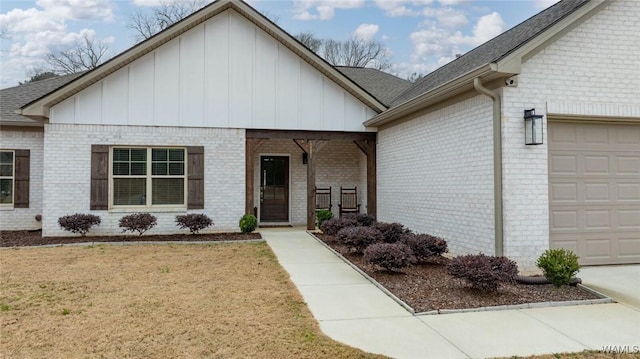 view of front of house with brick siding, a front yard, board and batten siding, and a garage