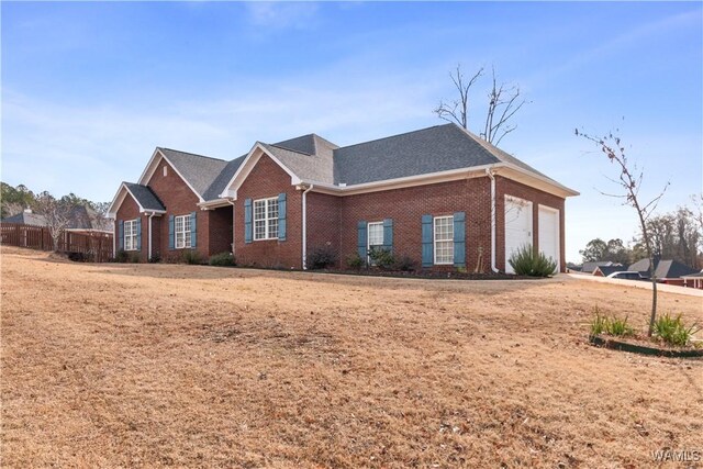 rear view of property with a garage, a wooden deck, and a yard