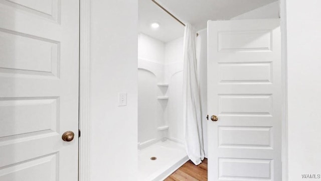 bathroom featuring wood-type flooring and walk in shower