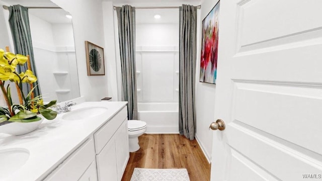 full bathroom featuring hardwood / wood-style floors, vanity, shower / tub combo, and toilet