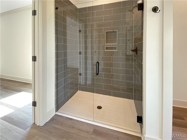 bathroom featuring hardwood / wood-style floors and a shower with shower door