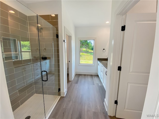 bathroom with hardwood / wood-style floors, vanity, toilet, and an enclosed shower