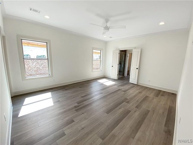 empty room with ceiling fan, dark hardwood / wood-style flooring, and ornamental molding