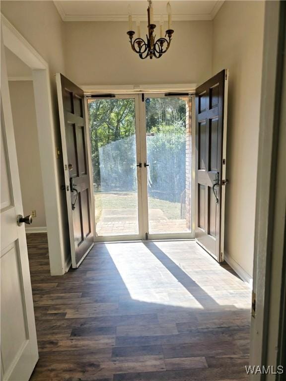 entryway with french doors, crown molding, dark hardwood / wood-style floors, and an inviting chandelier