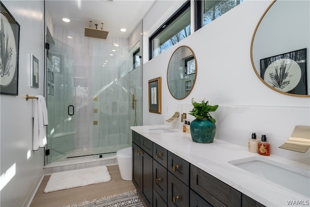 bathroom with vanity, hardwood / wood-style flooring, toilet, and a shower with shower door