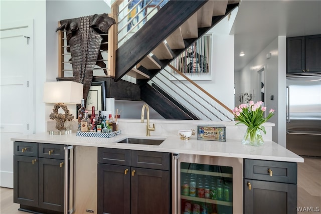 bar featuring sink, beverage cooler, and built in refrigerator