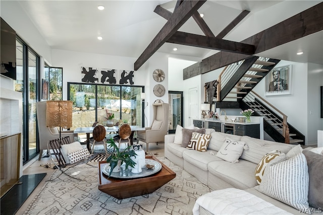 living room with beam ceiling and high vaulted ceiling