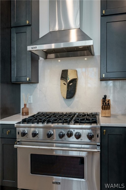 kitchen featuring high end stove, decorative backsplash, and wall chimney range hood