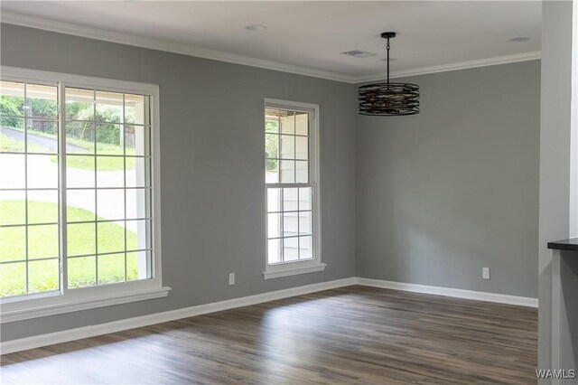 spare room with visible vents, crown molding, an inviting chandelier, baseboards, and dark wood finished floors