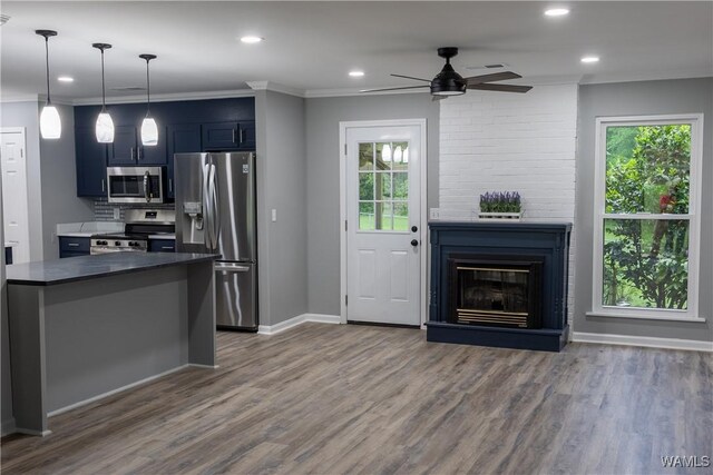 kitchen with a ceiling fan, dark countertops, dark wood finished floors, baseboards, and stainless steel appliances