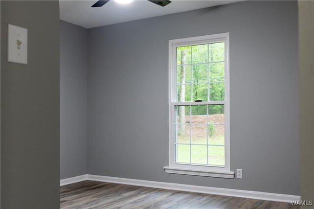 unfurnished room with baseboards, a ceiling fan, and wood finished floors