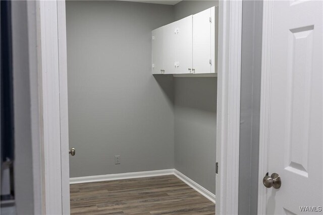 laundry area featuring baseboards and dark wood-style floors
