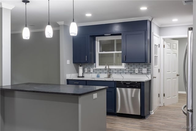 kitchen with a sink, appliances with stainless steel finishes, ornamental molding, and blue cabinets