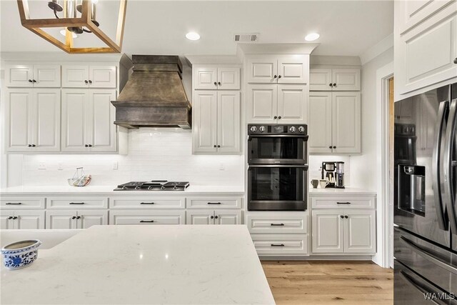 17505 Mormon Rd, Northport, AL 35475 - kitchen featuring appliances with stainless steel finishes, premium range hood, white cabinetry, and recessed lighting