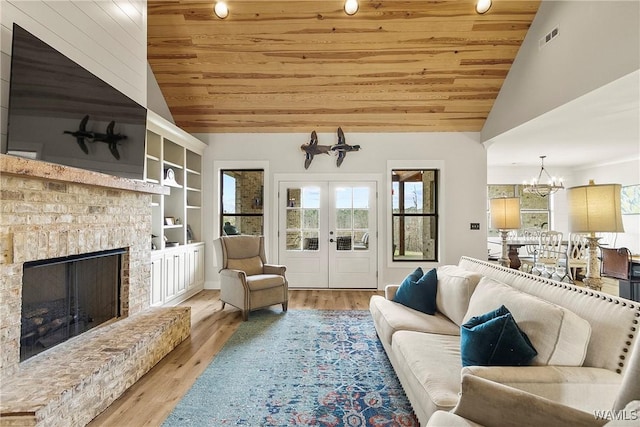 17505 Mormon Rd, Northport, AL 35475 - living room with lofted ceiling, wooden ceiling, a chandelier, a fireplace with raised hearth, and built in features