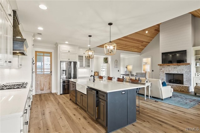 17505 Mormon Rd, Northport, AL 35475 - kitchen with appliances with stainless steel finishes, a sink, white cabinets, light wood-style flooring, and a kitchen breakfast bar