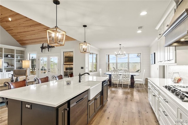 17505 Mormon Rd, Northport, AL 35475 - kitchen featuring a sink, a chandelier, custom range hood, white cabinetry, and stainless steel appliances