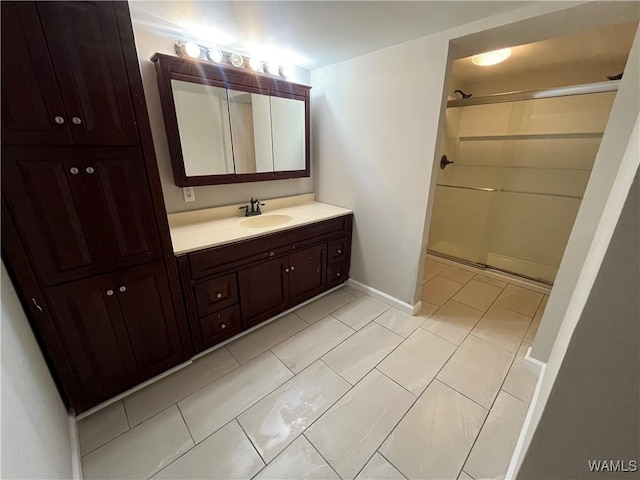 bathroom featuring a shower, vanity, and baseboards