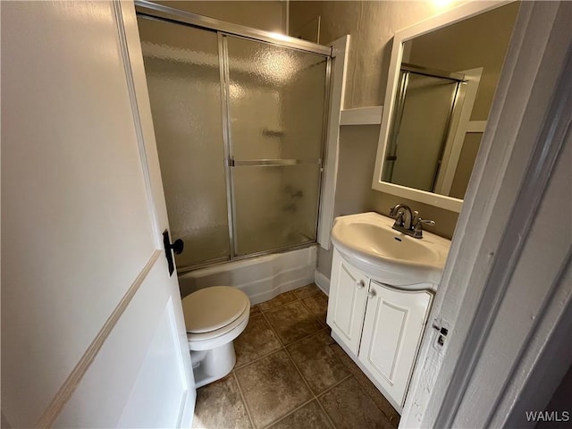 bathroom with toilet, shower / bath combination with glass door, vanity, and tile patterned floors