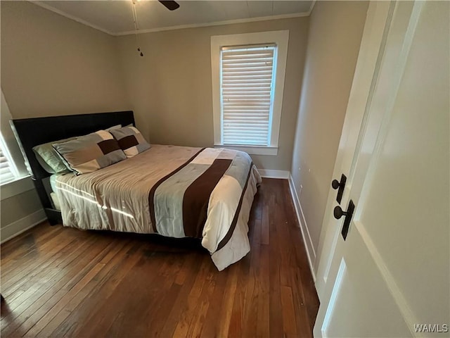 bedroom with baseboards, dark wood finished floors, and crown molding