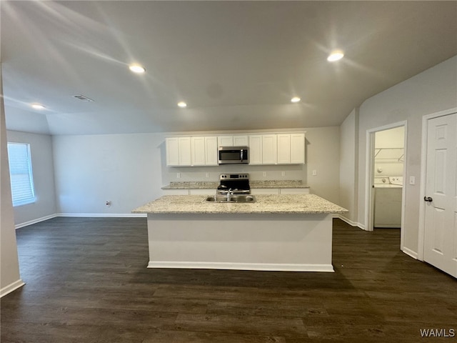 kitchen featuring washing machine and clothes dryer, a sink, stainless steel appliances, and dark wood-type flooring