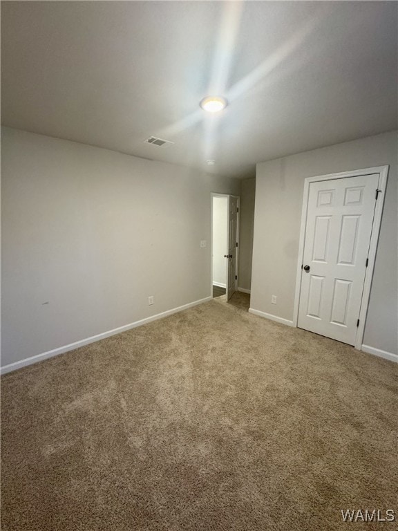unfurnished bedroom with baseboards, visible vents, and carpet