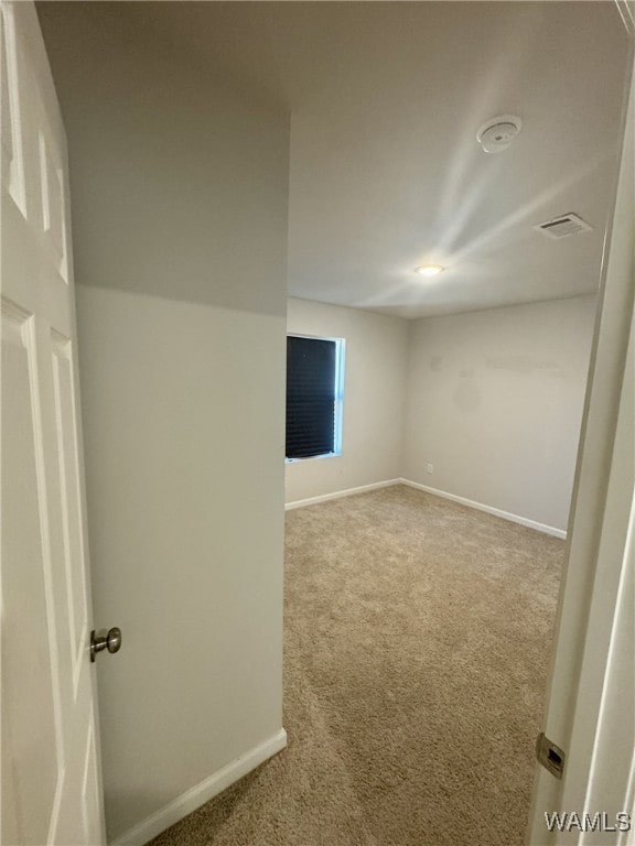 carpeted spare room with baseboards and visible vents