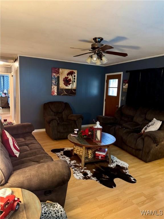 living room with hardwood / wood-style flooring, ceiling fan, and ornamental molding