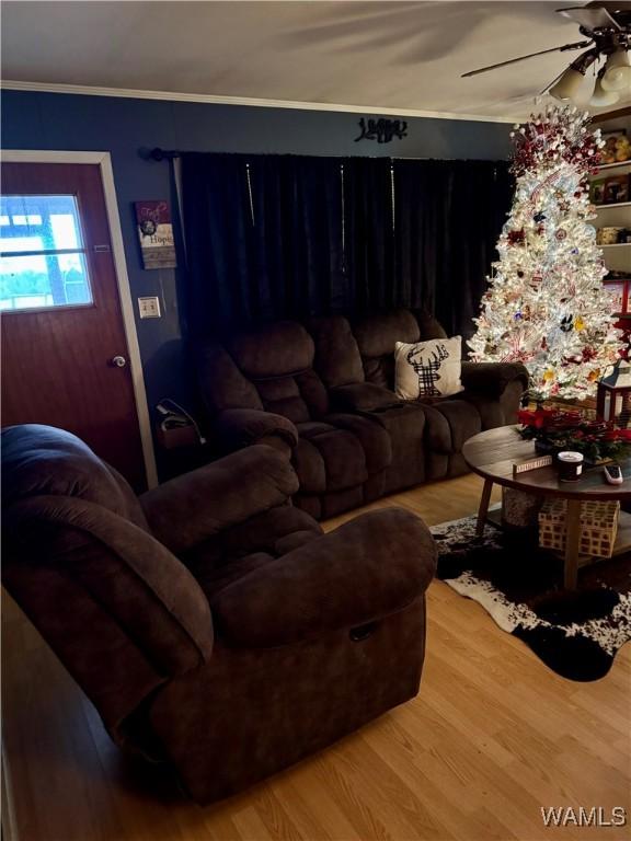 living room featuring hardwood / wood-style flooring, ceiling fan, and crown molding