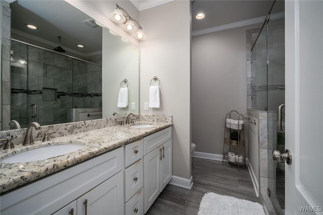 bathroom with crown molding, recessed lighting, a sink, and a stall shower