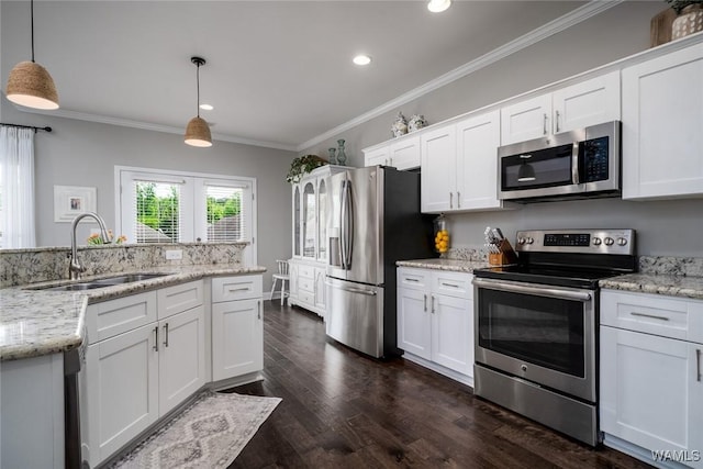 kitchen with a sink, appliances with stainless steel finishes, white cabinets, and crown molding