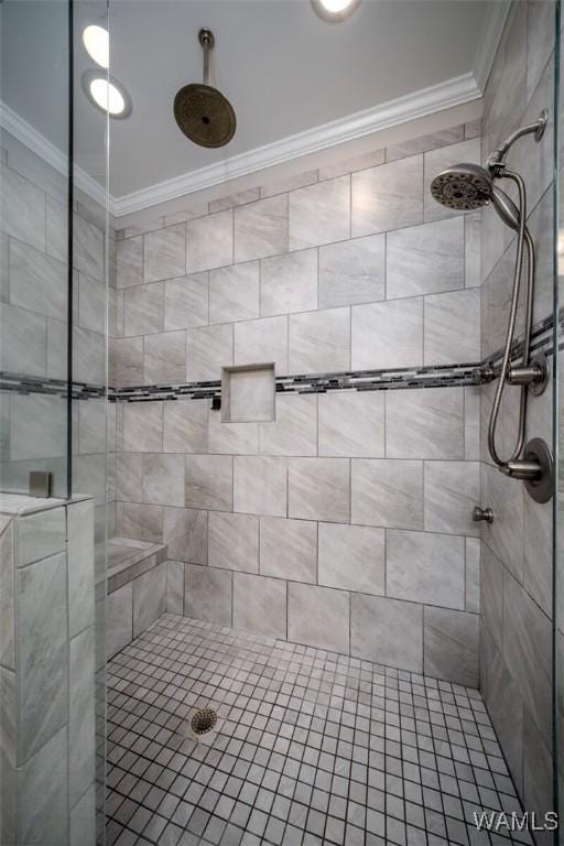 full bath featuring a tile shower and ornamental molding
