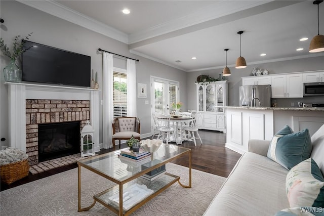 living room featuring ornamental molding, a fireplace, recessed lighting, and dark wood-type flooring