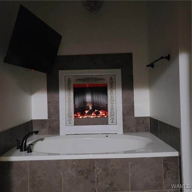 13712 Tab Dr, Northport, AL 35475 - bathroom with a bath and a warm lit fireplace