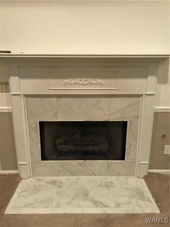 interior details featuring a tile fireplace