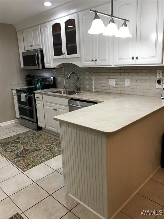 kitchen with appliances with stainless steel finishes, white cabinets, and a sink