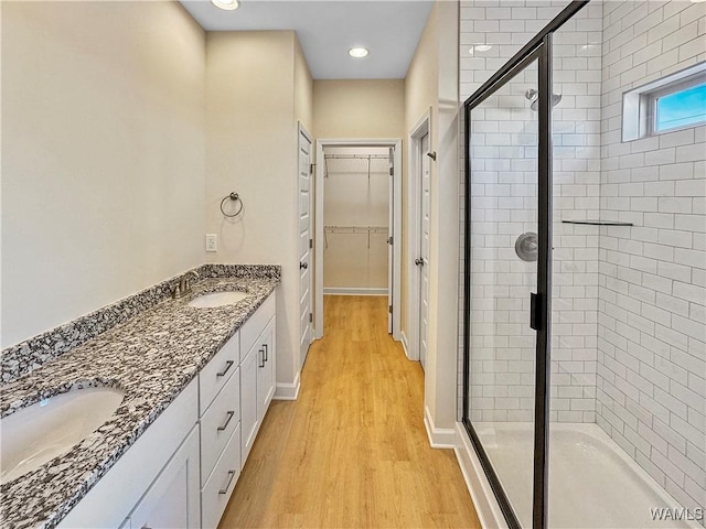 bathroom with an enclosed shower, vanity, and wood-type flooring