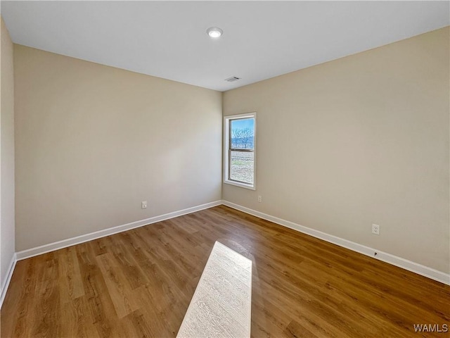 spare room with wood-type flooring