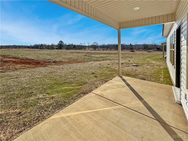 view of yard featuring a rural view and a patio area