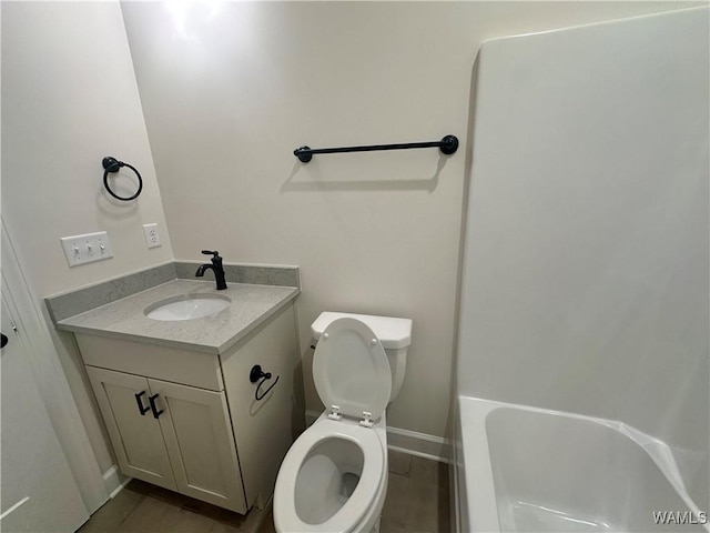 bathroom featuring a bath, wood-type flooring, vanity, and toilet