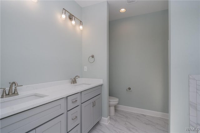 bathroom with marble finish floor, toilet, baseboards, and a sink