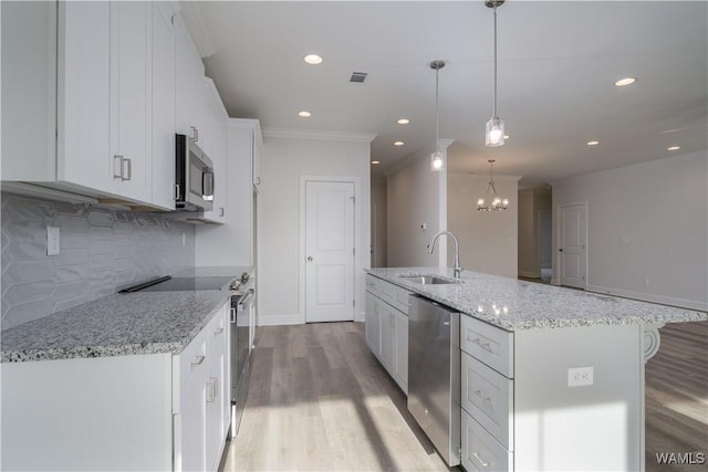 kitchen featuring visible vents, stainless steel appliances, a sink, white cabinetry, and light wood-type flooring