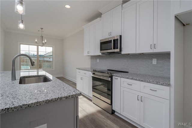 kitchen with a sink, crown molding, backsplash, and stainless steel appliances