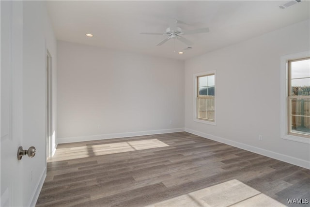 unfurnished room with wood finished floors, visible vents, and baseboards